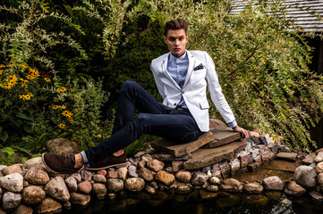 Fototapeta premium young beautiful fashionable man against autumn garden.