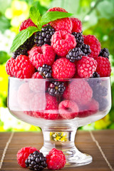 Sweet fresh fruits in glass goblet with mint leaf