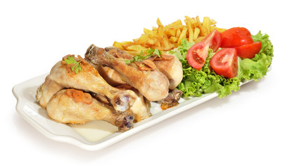Muslos de pollo con ensalada y patas fritas.