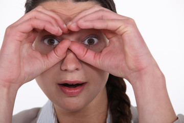 Woman making binoculars gesture with hands