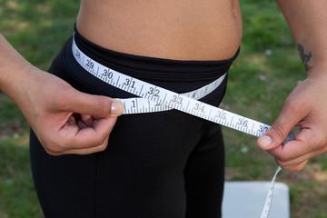 Young hispanic female using a tape measure