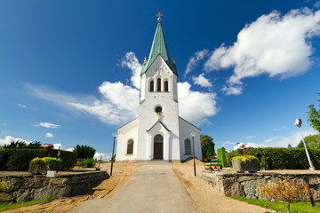 Fototapeta na wymiar Traditional Swedish white church over sunny blue sky