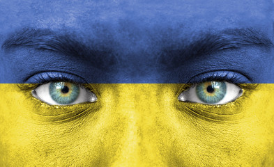 Human face painted with flag of Ukraine