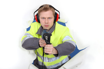 Naklejka premium Man in reflective jacket holding power drill