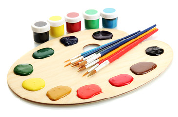 wooden art palette with  paint and brushes.isolated on white