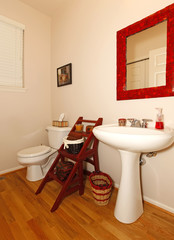 Small bathroom with sink and toilet and hardwood floor.