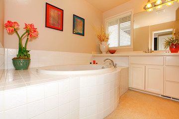 Fototapeta na wymiar Bathroom with large round white tub and cabinets