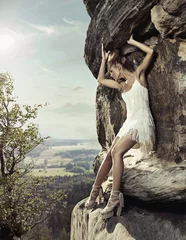 Keuken spatwand met foto Blonde beauty posing on a dangerous rock © konradbak