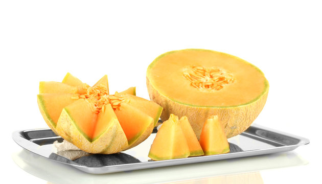 Cut melon on metal tray isolated on white