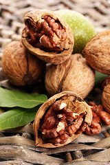 walnuts with green leaves, on  wicker background