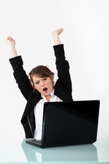 happy woman gesturing in front of laptop computer