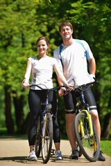 Obraz premium Happy couple riding bicycle outdoors