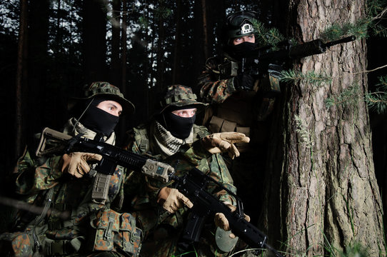 Military in ambush. Near a tree. In full gear