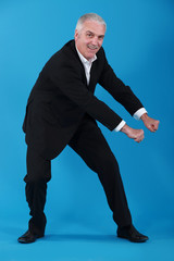 Mature businessman pretending to pull