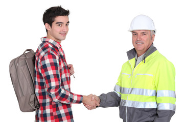 young apprentice shaking hands with senior foreman