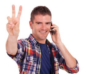 Young man on the phone shows peace sign