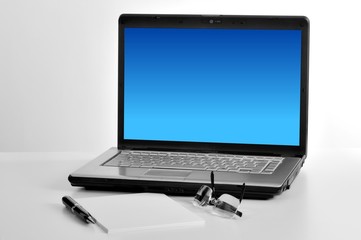 laptop isolated white screen with notepad, pen and glass