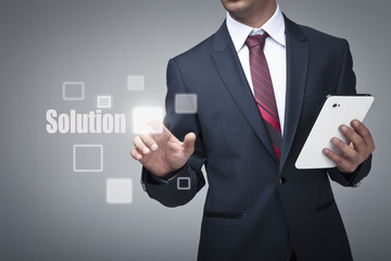 Businessman with tablet pushing on a solution button