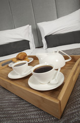 Tray with coffee on a bed in a hotel room  