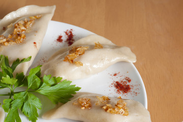 Ruskie Pierogi podane z smażoną cebulką, sałatą i szczypiorkiem