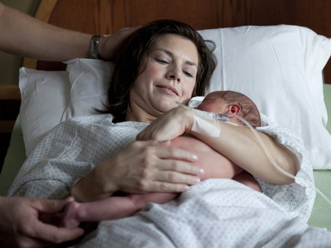 USA, Utah, Payson, Mother embracing newborn baby
