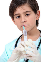 Little boy with syringe dressed as doctor