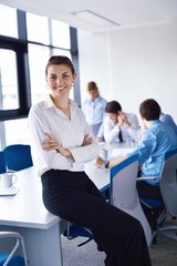 business woman with her staff in background at office