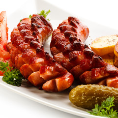 Grilled sausages, baked potatoes and vegetables