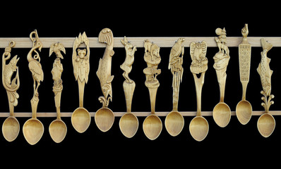 Sculpted wooden spoons isolated on black background.