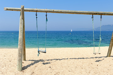 Double swing on beach by the sea