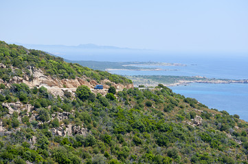 Van driving on mountain road near coast