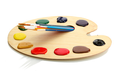 wooden art palette with  paint and brushes.isolated on white