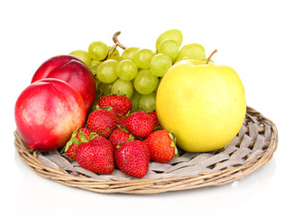 ripe sweet fruits and berries on wicker mat isolated on white