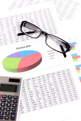 Documents, calculator and glasses close-up.