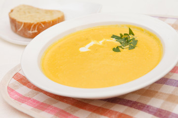 Pumpkin soup in white bowl