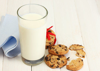 glass of milk and chocolate chips cookies with red ribbon