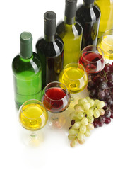 Obraz premium bottles and glasses of wine and ripe grapes isolated on white