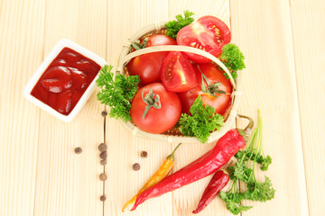Still life tomatoes ketchup and herbs on wooden table
