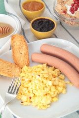 prima colazione con uova wurstel marmellate miele e cereali