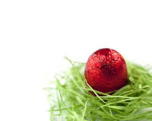 oeuf de pacques rouge sur un nid de verdure