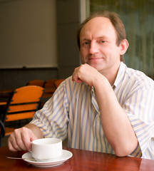 Happy aged man with coffee in cafe
