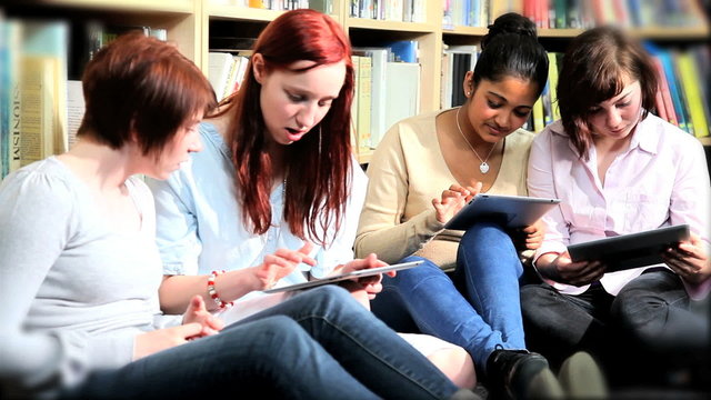 Multi ethnic students using university net on tablet