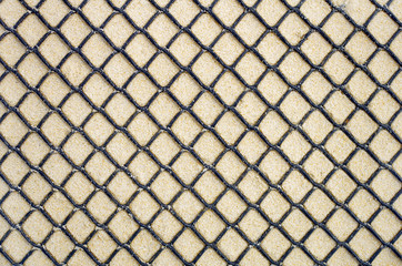 Fototapeta premium Fond de sable derrière une grille plastique