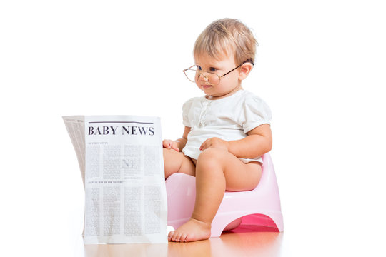 funny baby girl reading newspaper on chamberpot