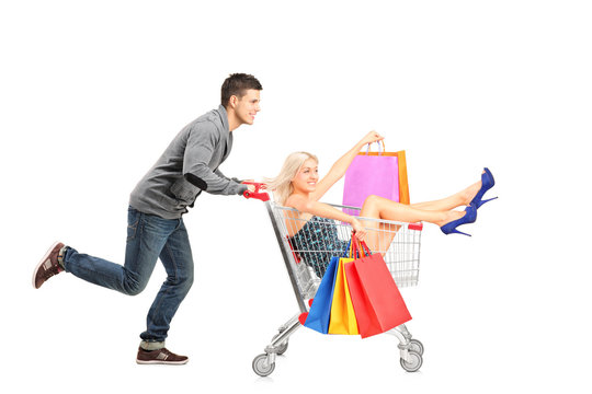 Person pushing a shopping cart, happy woman with bags in it