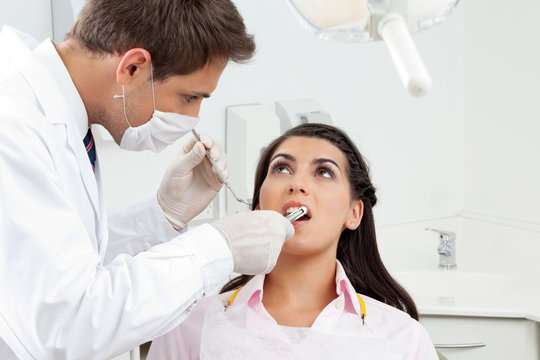 Dentist Examining Patient's Mouth