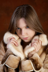 Studio portrait of the girl in a fur coat