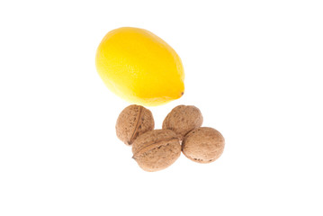 Four walnuts and lemon on a white background
