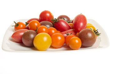 Fresh mixed tomatoes on white plate