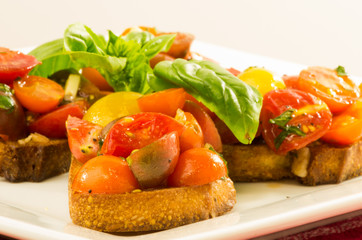 Fresh bruschetta with mixed tomatoes cheese and basil on plate